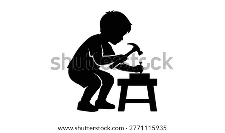 Silhouette of a young boy intently hammering a nail into wood
