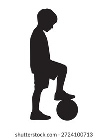 Silhouette eines kleinen Jungen, der hinunter auf einen Fußball schaut und das Spiel betrachtet.