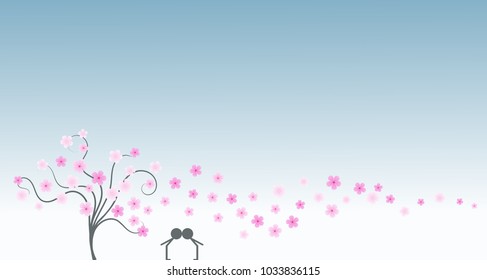 Silhouette of young couple in love kissing next to a tree and under cherry petals and blossoms in anniversary day