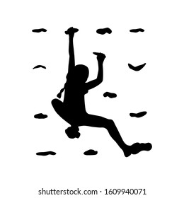 Silhouette of a young rock climber on a climbing wall.