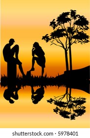 silhouette of young romantic couple relaxing together by a river