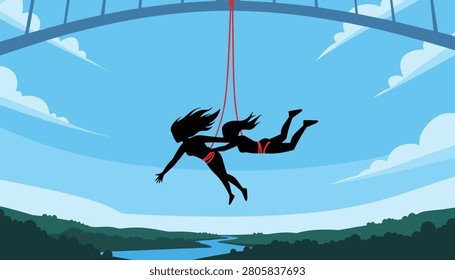 Silhouetted figures of two brave young women bungee jumping together from a high bridge over a beautiful forest river canyon.