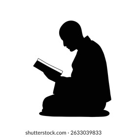Silhouetted person kneeling reading a book