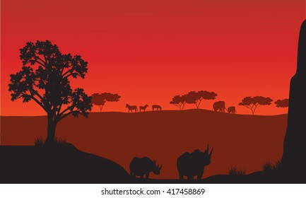 Silhouettes of african with rhino animals and red backgrounds