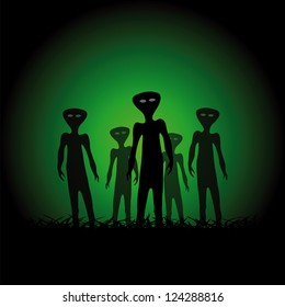 Silhouettes of aliens on the green background