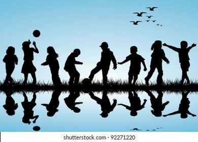 Silhouettes of children playing near a water