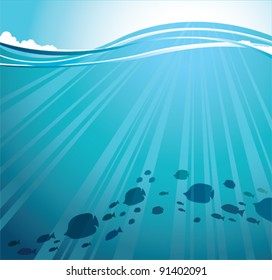 Silhouettes of fish and sun rays in a sea