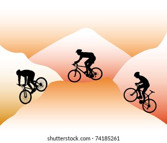 silhouettes of mountain bikers on a background of mountain slopes