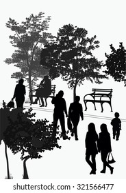 silhouettes of people walking in the park among the trees