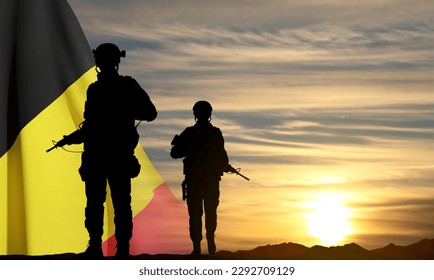 Silhouettes of a soldiers against the sunset with Belgium flag. EPS10 vector