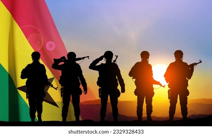 Silhouettes of a soldiers with Ghana flag against the sunset. EPS10 vector