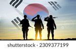 Silhouettes of a soldiers on background of sunset and flag of South Korea. Armed forces of South Korea concept. EPS10 vector
