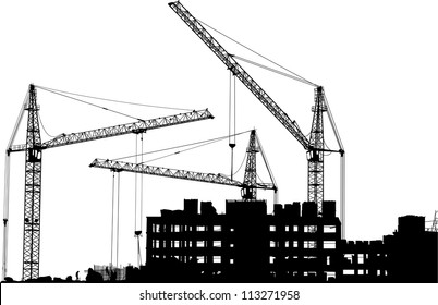 Silhouettes of three cranes working on the building