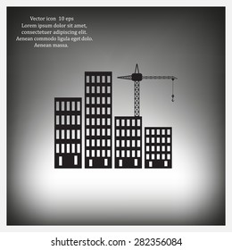 Silhouettes of three cranes working on the building