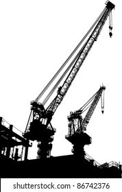 Silhouettes of two cranes on building