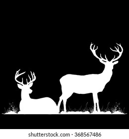 Silhouettes of two deers lying on the grass.