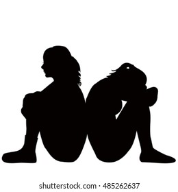 Silhouettes of two sad young women sitting on the floor