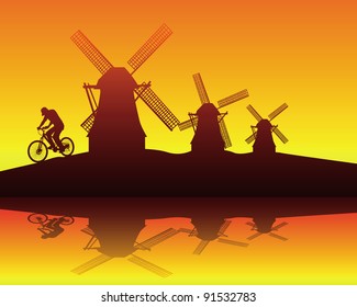 silhouettes of windmills and the rider on an orange background