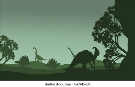 Silhouettte of parasaurolophus and stegosaurus in the fields