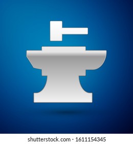 Silver Anvil for blacksmithing and hammer icon isolated on blue background. Metal forging. Forge tool.  Vector Illustration