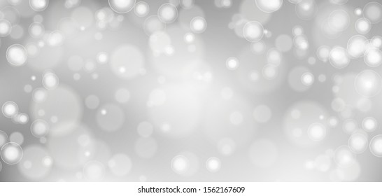 Silver bokeh background. Christmas glowing lights with sparkles. Holiday decorative effect.