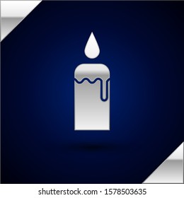 Silver Burning candle in candlestick icon isolated on dark blue background. Cylindrical candle stick with burning flame.  Vector Illustration