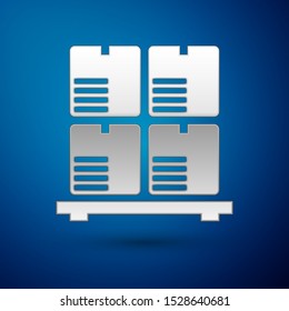 Silver Cardboard boxes on pallet icon isolated on blue background. Closed carton delivery packaging box with fragile signs.  Vector Illustration