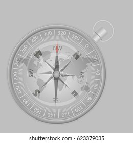 silver compass on a world map indicating the direction to the North 