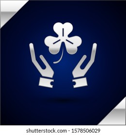 Silver Human hands holding four leaf clover icon isolated on dark blue background. Happy Saint Patrick day.  Vector Illustration