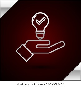 Silver line Light bulb in hand icon isolated on dark red background. Concept of idea.  Vector Illustration