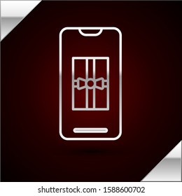 Silver line Smartphone with gift box on the screen icon isolated on dark red background. Merry Christmas and Happy New Year.  Vector Illustration
