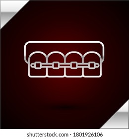 Silver line Teeth with braces icon isolated on dark red background. Alignment of bite of teeth, dental row with with braces. Dental concept.  Vector Illustration