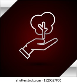 Silver line Tree in hand of environmental protection icon isolated on dark red background. Seed and seedling. Planting sapling. Ecology concept.  Vector Illustration