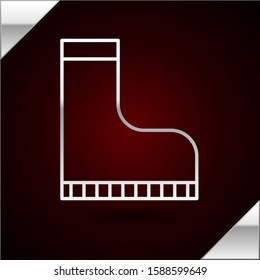 Silver line Waterproof rubber boot icon isolated on dark red background. Gumboots for rainy weather, fishing, gardening.  Vector Illustration