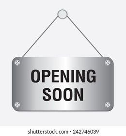 silver metallic opening soon sign hanging on the wall 