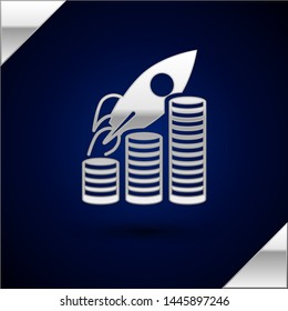 Silver Rocket flying up on coins growth chart icon isolated on dark blue background. Graph that shows increase in sales.  Vector Illustration