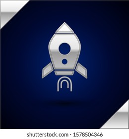 Silver Rocket ship with fire icon isolated on dark blue background. Space travel.  Vector Illustration
