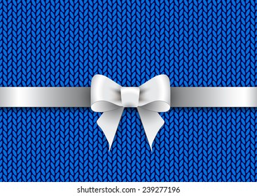 Silver satin bow on a blue knitted background