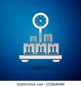 Silver Scale with cardboard box icon isolated on blue background. Logistic and delivery. Weight of delivery package on a scale.  Vector Illustration