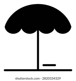 A simple black beach umbrella stands alone on a sandy shore, evoking relaxation