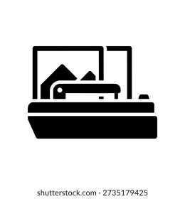 Simple black and white illustration of a flatbed scanner with a document on the glass surface.