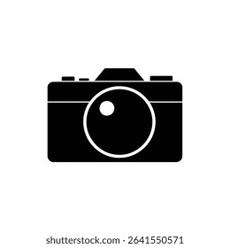 A simple black and white image showcases a camera icon. The design features a clearly visible, circular lens, rendered in a minimalist style against the plain backdrop.