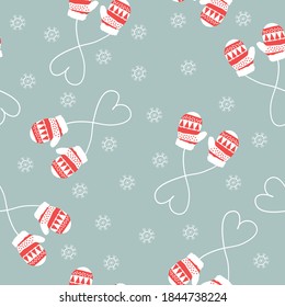 Simple Christmas pattern. Cute red and white patterned mittens. Snowflakes. Pale blue background. Vector texture. Winter print for textiles and packaging.