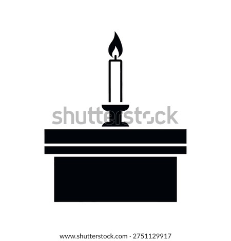 A simple, clean black and white icon of a lit candle in a holder, placed on a flat surface or table.