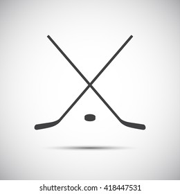 Simple crossed hockey stick with puck, vector icon