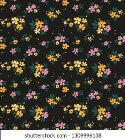 Simple cute pattern in small yellow and lilac flowers on dark gray background. Liberty style. Ditsy print. Floral seamless background. The elegant the template for fashion prints.
