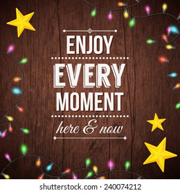 Simple Enjoy Every Moment Texts on Wooden Background with Yellow Stars and Series Lights Designs.