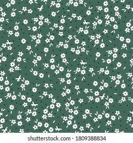 Simple floral pattern. Print with small flowers.Cute white flowers on a green background. Fashionable print is suitable for Wallpaper.