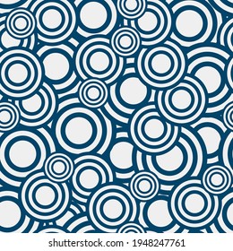 simple geometric seamless pattern. overlapping azure rings of different sizes randomly arranged on a light background. vector