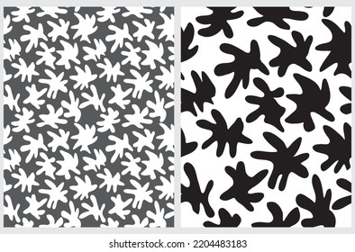 Simple Hand Drawn Irregular Spots Seamless Vector Patterns. White and Black Irregular Shape Stains on a Dark Gray and White Background. Infantile Style Abstract Spotted Vector Print.